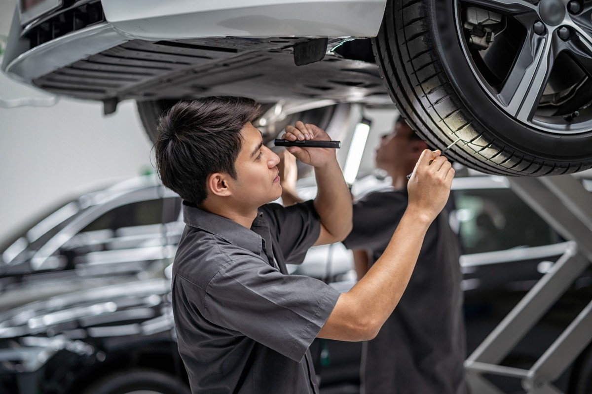 mechanic looking car over