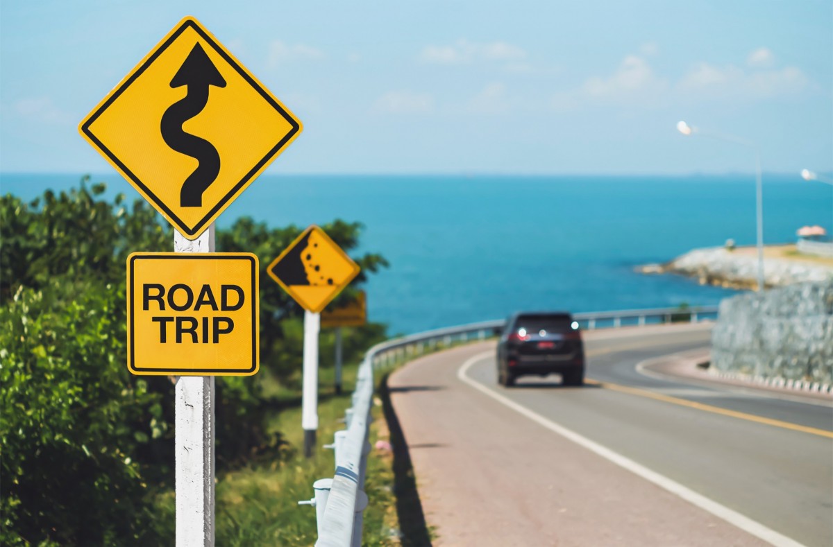 Car driving past a road trip sign